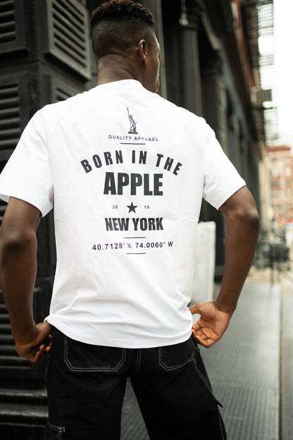 Oversized white t-shirt, heavyweight and 100% cotton. Black embroidered BITA Torch on left chest, grey jock tag with black born in the apple text on bottom left edge, and black screen printed Born In  The Apple text covers the back. Raglan sleeves. 